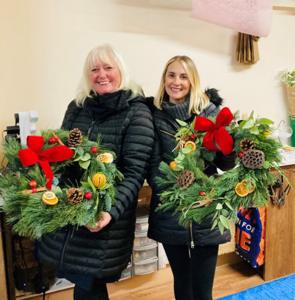Two women making Christmas wreaths