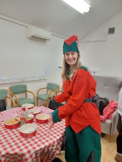 Lady dressed up as an elf at a craft table