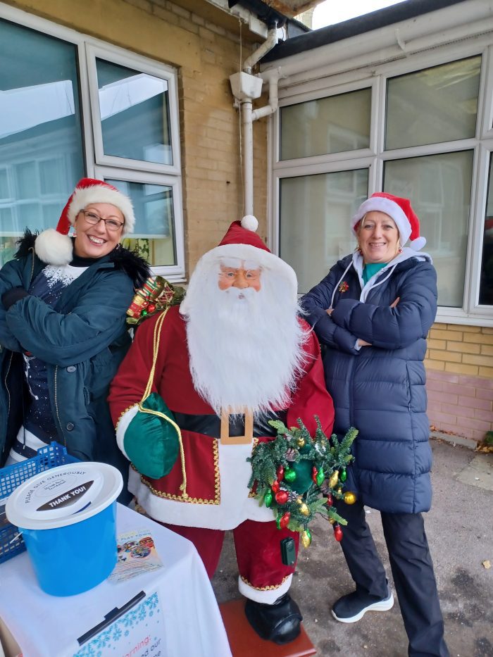 Two female volunteers with a model Santa