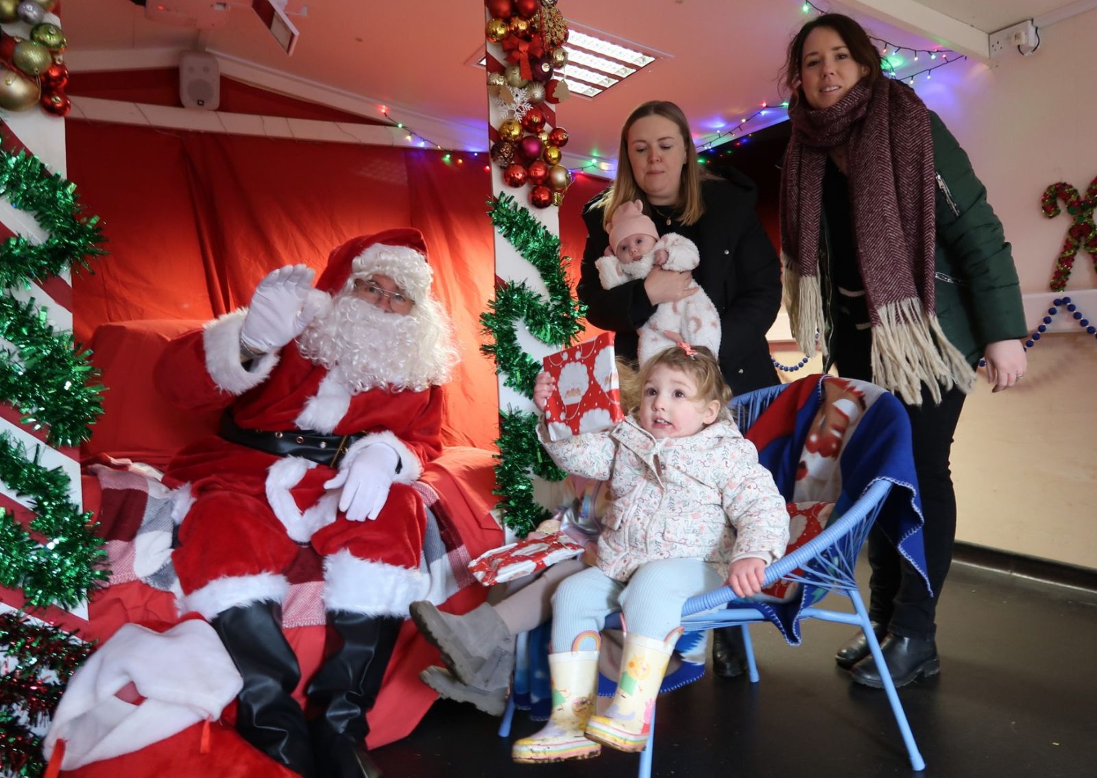 Father Christmas with child, baby and two ladies in the grotto