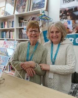 Two ladies smiling in the charity shop