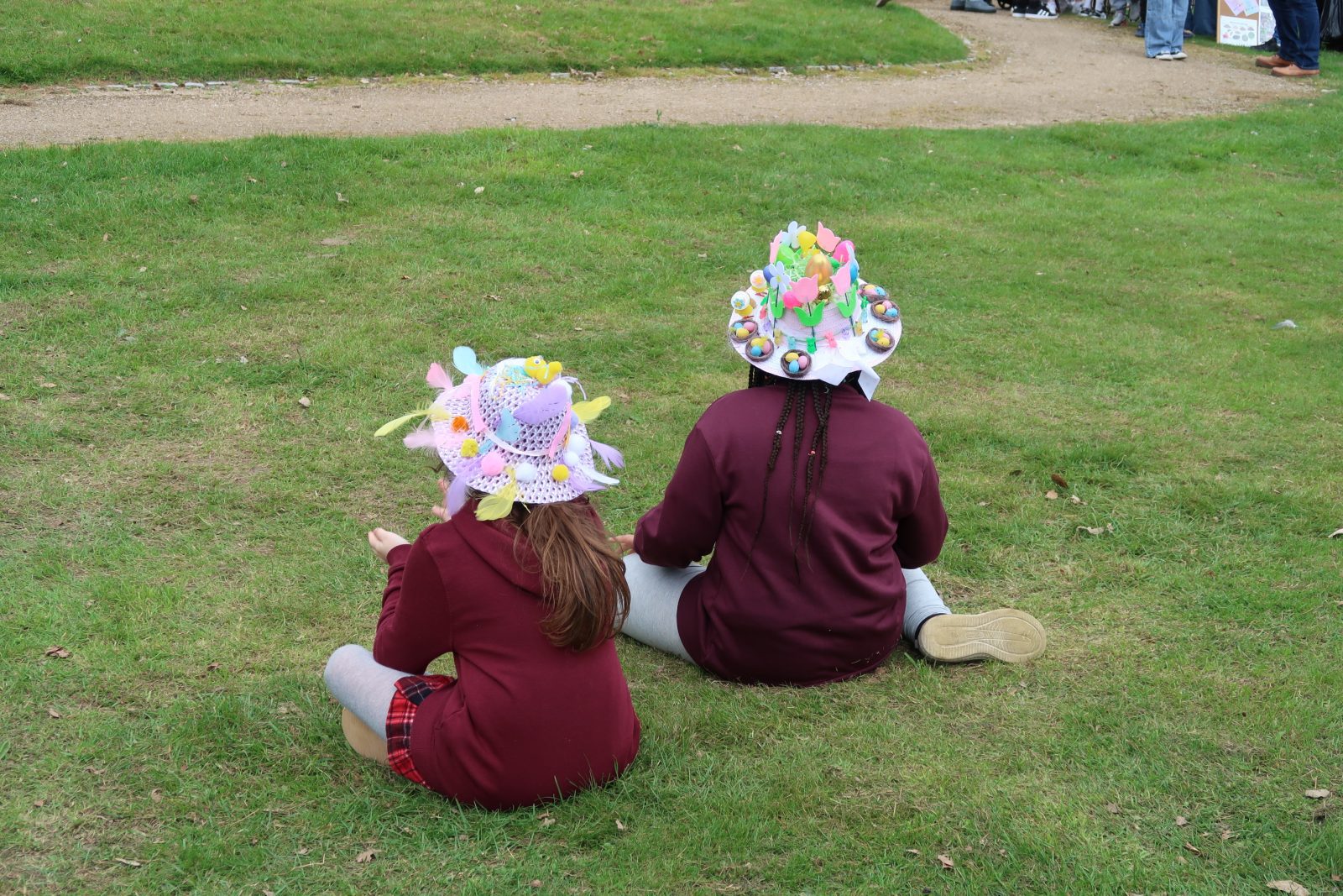 Two children wearing bonnets on the grass