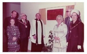 Photo of key people next to a wooden plaque opening the wing