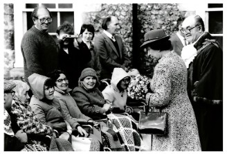 Black and white photo of residents with Queen Elizabeth II