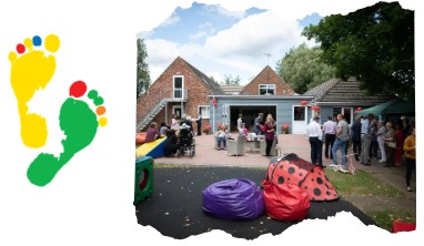 People standing in a garden with building behind them, with red balloons and bean bags