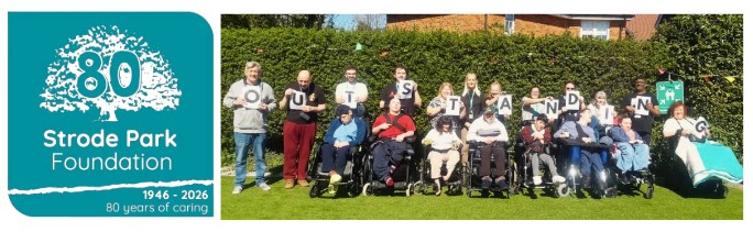 Logo and people in garden holding a sign saying outstanding