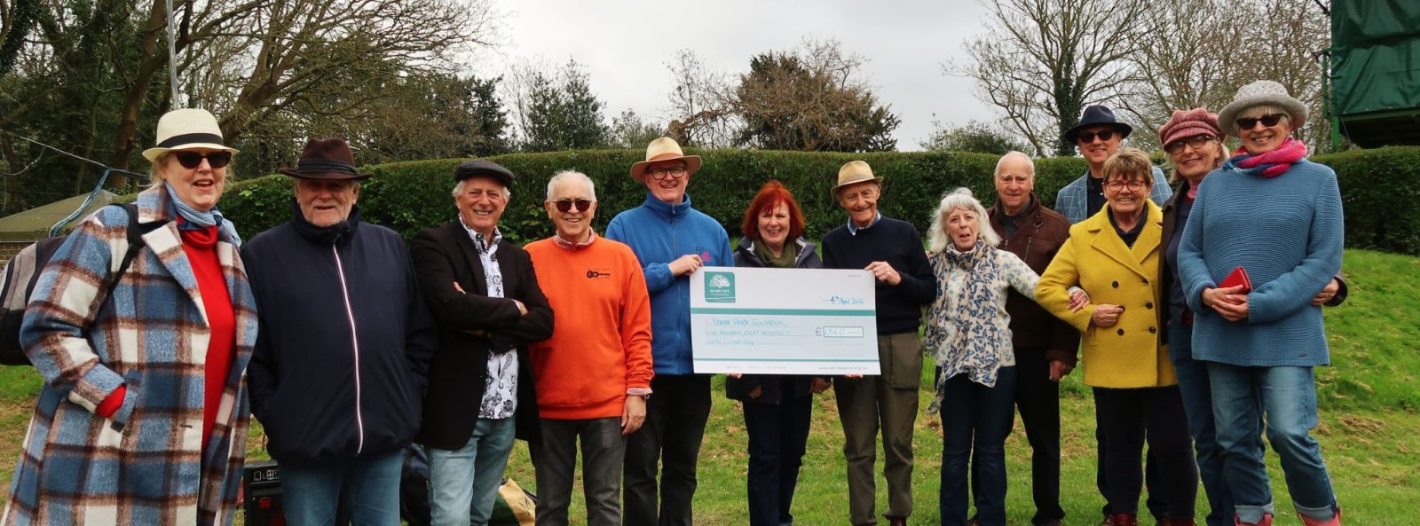 Band members outside holding cheque
